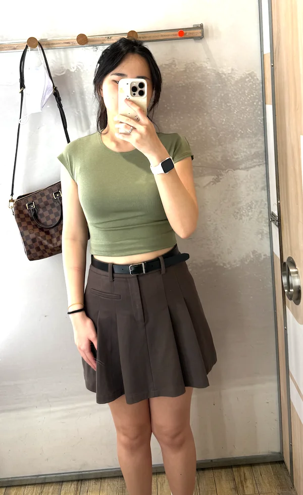 The original shopper photo, wearing a green top and brown skirt.