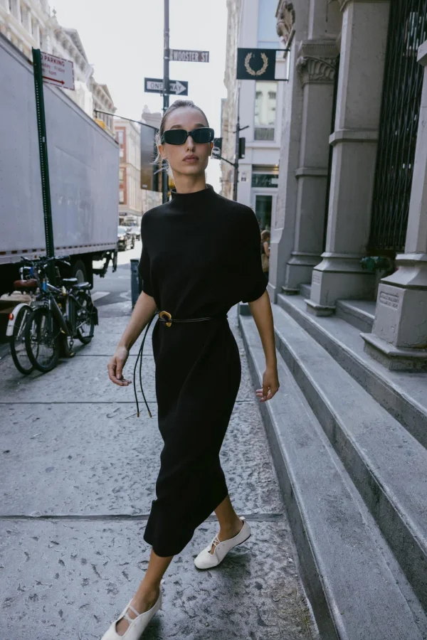 The selected black dress shown on a model.